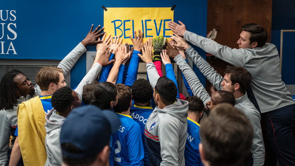 AFC Richmond players touching the Believe sign in the locker room